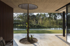 La vivienda Garafulic consta con un terreno privilegiado rodeado de vegetación que está situado en una urbanización cerrada en la zona del Urubó. La topografía natural del terreno permite que la volumetría de la casa se apoye en el punto más alto del mismo, aprovechando así los desniveles para poder generar una planta de servicio en el subsuelo. Esto nos permite resolver el programa de la vivienda en 3 niveles, pero al mismo tiempo mantener una composición de dos volúmenes que se solapan y se posan sobre el terreno natural.

El acceso principal nos dirige hacia la planta baja, la que está resuelta bajo el concepto de `planta libre´. Diferentes áreas de servicio como el sauna, la escalera principal,  el shaft, la despensa y  la vinoteca; funcionan como volúmenes de separación y actúan como colchones entre los distintos programas. Con el fin de no generar habitaciones cerradas, la planta baja genera un espacio en común cuyas divisiones crean una fragmentación del espacio entre los distintos programas sin afectar la circulación libre

El recibidor o hall funciona como un distribuidor entre el family room y el pasillo principal, que nos lleva al cuarto de huéspedes, la cocina o el living comedor.  Entre el living-comedor y el gimnasio podemos apreciar una galería que nos lleva a una cubierta verde que mira hacia el patio interior y la piscina.

En el segundo piso contamos con el estar familiar y dos habitaciones en suite. La habitación principal cuenta con una pequeña terraza que aprovecha las mejores vistas del terreno hacia un pequeño bosque localizado al frente del mismo.