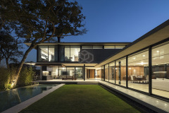 La vivienda Garafulic consta con un terreno privilegiado rodeado de vegetación que está situado en una urbanización cerrada en la zona del Urubó. La topografía natural del terreno permite que la volumetría de la casa se apoye en el punto más alto del mismo, aprovechando así los desniveles para poder generar una planta de servicio en el subsuelo. Esto nos permite resolver el programa de la vivienda en 3 niveles, pero al mismo tiempo mantener una composición de dos volúmenes que se solapan y se posan sobre el terreno natural.

El acceso principal nos dirige hacia la planta baja, la que está resuelta bajo el concepto de `planta libre´. Diferentes áreas de servicio como el sauna, la escalera principal,  el shaft, la despensa y  la vinoteca; funcionan como volúmenes de separación y actúan como colchones entre los distintos programas. Con el fin de no generar habitaciones cerradas, la planta baja genera un espacio en común cuyas divisiones crean una fragmentación del espacio entre los distintos programas sin afectar la circulación libre

El recibidor o hall funciona como un distribuidor entre el family room y el pasillo principal, que nos lleva al cuarto de huéspedes, la cocina o el living comedor.  Entre el living-comedor y el gimnasio podemos apreciar una galería que nos lleva a una cubierta verde que mira hacia el patio interior y la piscina.

En el segundo piso contamos con el estar familiar y dos habitaciones en suite. La habitación principal cuenta con una pequeña terraza que aprovecha las mejores vistas del terreno hacia un pequeño bosque localizado al frente del mismo.